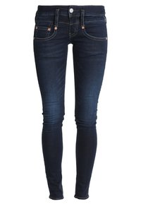 Dark blue skinny jeans with front and back pockets, copper rivets, button, belt loops, and faded detailing on thighs and knees.
