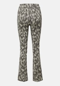 Spodnie z wysokim stanem i rozszerzanymi nogawkami w czarno-biały wzór wężowej skóry na jednolitym tle.