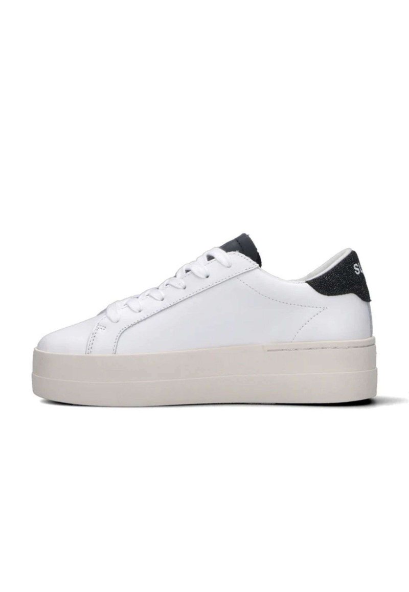 Sneaker basso bianco con suola spessa beige, lacci bianchi e tassello sul tallone nero con testo bianco su uno sfondo bianco semplice.