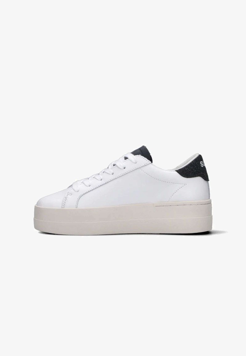 Sneaker basso bianco con suola spessa beige, lacci bianchi e tassello sul tallone nero con testo bianco su uno sfondo bianco semplice.