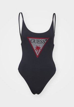 Zwart badpak met dunne bandjes, voorzien van een driehoekige grafische afbeelding met "GUESS?" in zilveren en rode strass-steentjes en een palmboomontwerp.