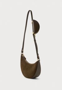 Bolsa de ombro em forma de crescente, em camurça e couro castanho-escuro, com ferragens douradas e um pequeno bolso semi-circular destacado na alça ajustável.