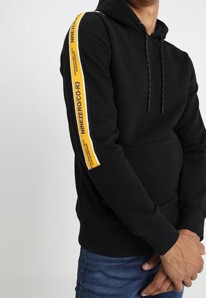 Black hoodie featuring a yellow stripe with text along the left arm, drawstrings at the hood, and ribbed cuffs and hem.