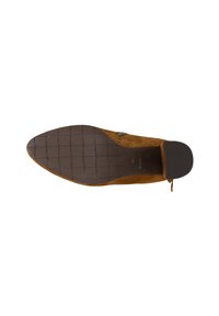 Scarpa in pelle scamosciata marrone con punta affilata, soletta testurizzata, suola in gomma a motivi e tacco basso. Presenta un dettaglio decorativo con cinturino.