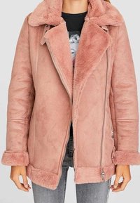 Roze nepbontjas met een brede kraag, ritssluiting en lange mouwen. Heeft een zachte textuur en omgeslagen manchetten.