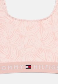 Ροζ ανοιχτό ροζ σουτιέν με σχέδιο φύλλου, με λευκή ταινία λογότυπου που γράφει "TOMMY HILFIGER" και τυλίγεται γύρω απ ό το κάτω μέρος. Μαλακή υφή υφάσματος.