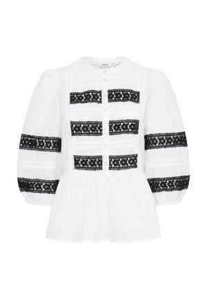 Weißes Blusenshirt mit schwarzen Spitzelementen, puffärmeligen Ärmeln, Knopfleiste und gerafftem Bund. Besitzt horizontale Streifen und Lochmuster.