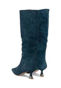 Botas altas de ante en azul oscuro con punta afilada y un exclusivo tacón de kitten heel con detalles metálicos. Textura suave, diseño ajustado.