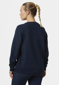 Sudadera de algodón azul marino con cuello redondo, puños acanalados y dobladillo. La vista trasera muestra un corte relajado y un diseño minimalista.