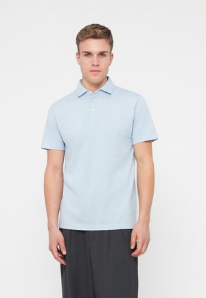 Light blue polo shirt made of cotton, featuring a collar, short sleeves, and a small logo on the chest. Smooth texture and classic fit.