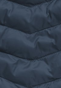 Tissu matelassé bleu marine avec un motif en chevron, présentant une texture lisse et de légères lignes de grille pour plus de détails.