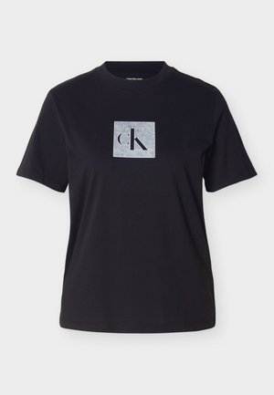 Svart bomulls-T-skjorte med korte ermer, med en grått firkantet logo med "CK" i svart i midten. Jevn tekstur, klassisk passform.