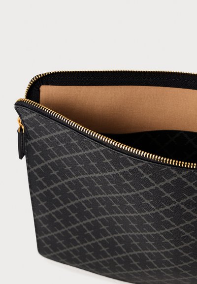 Svart fodral med dragkedja, tillverkat av texturerat material och med ett geometriskt mönster. Insidan är beige med en slät yta och guld-färgad dragkedja.