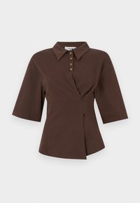Polo en coton marron avec un col, des manches courtes, une fermeture à cinq boutons et une coupe asymétrique avec un pli latéral.