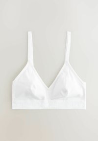 Bralette blanche à bonnets souples avec fines bretelles réglables et large bande sous la poitrine, en tissu côtelé.