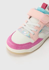 Zapatillas blancas y rosas con detalles de gamuza rosa, lengüeta de malla y detalles holográficos. Cuenta con cordones blancos y una correa de Velcro.