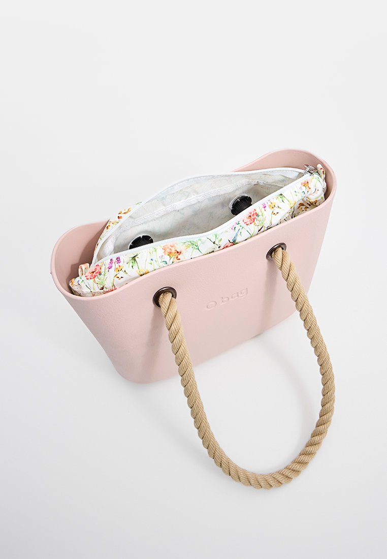 Różowa torba na ramię wykonana z miękkiego materiału z naturalnym sznurkiem uchwytem. Wnętrze zawiera zapinaną na zamek saszetkę w kwiatowy wzór.