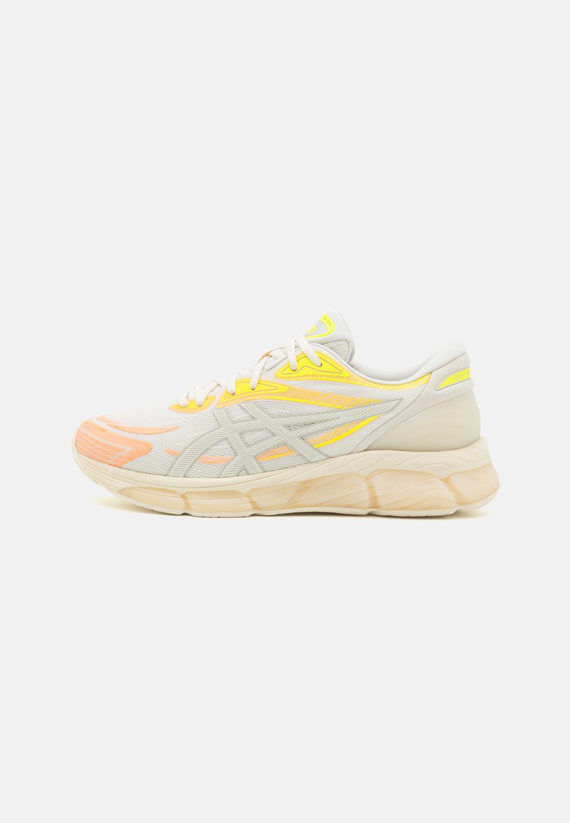 Scarpa da corsa leggera con tomaia in mesh traspirante, accenti gialli e arancioni, suola intermedia beige imbottita e suola esterna in gomma.