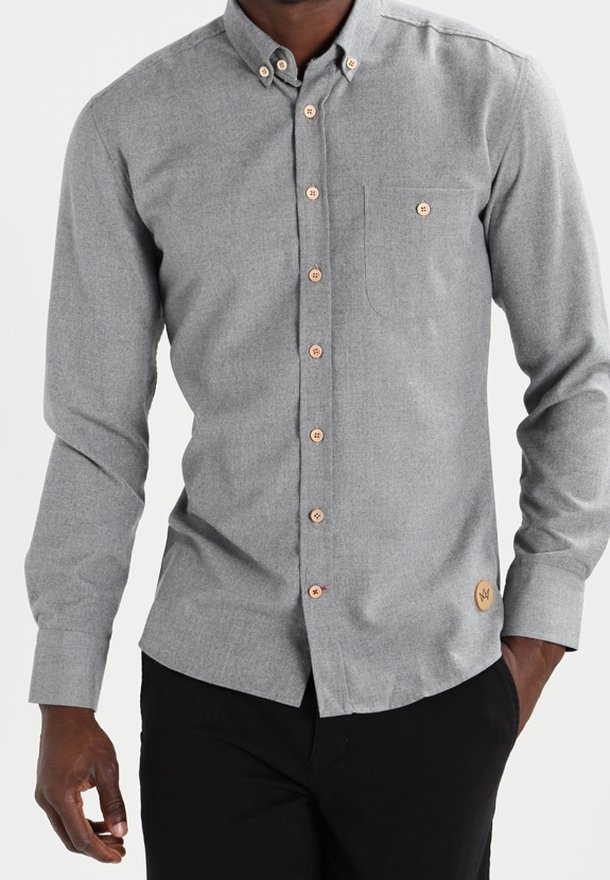 Camisa gris de botones con mangas largas, un único bolsillo en el pecho, botones en contraste y un acento de cuero de marca en el dobladillo.