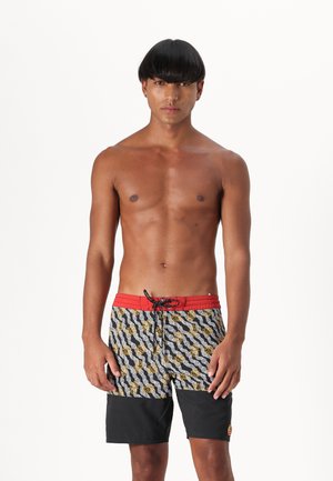 Maudymosi šortai su juoda ir auksine bangų raštu, raudona elastinga juosta, su raišteliu ir tvirtu juodu apatine dalimi. Lengvas, greitai džiūstantis medžiaga.