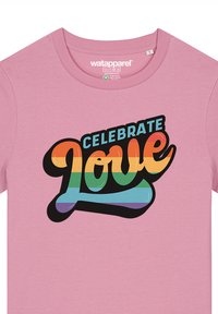 Roze katoenen T-shirt met een gedurfde, multikleurige graphic die "CELEBRATE LOVE" in een modern, rond lettertype met een zwarte omtrek afbeeldt.