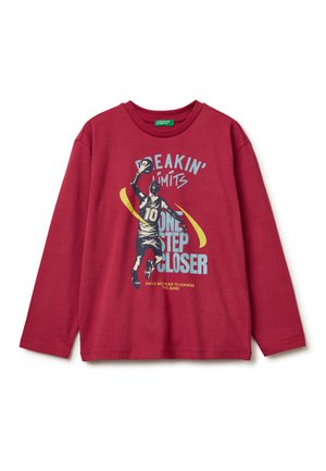 Rotes Langarmshirt mit grafischem Druck, das einen Basketballspieler und Textelemente zeigt. Hergestellt aus weichem Material mit einer lockeren Passform.