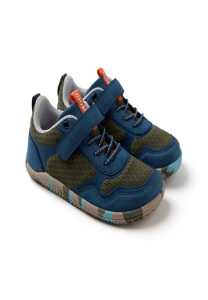 Blaue und olivgrüne Kinderturnschuhe mit orangefarbenen Zuglaschen, Klettverschlüssen und derben Sohlen im Camouflage-Muster auf weißem Hintergrund.