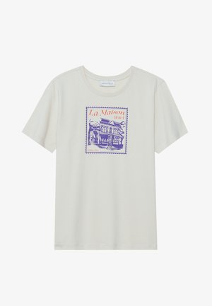 Krēma krāsas kokvilnas T-krekls ar purpursarkanu un oranžu grafiku, kurā attēlots viesnīca, ietverta zīmogam līdzīgā apmalē. Īsas piedurknes, apaļa kakla izgriezuma forma.