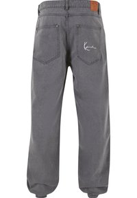 Pantaloni in denim grigio con una vestibilità rilassata, caratterizzati da due tasche posteriori, cuciture decorative e un'etichetta con logo sulla vita.