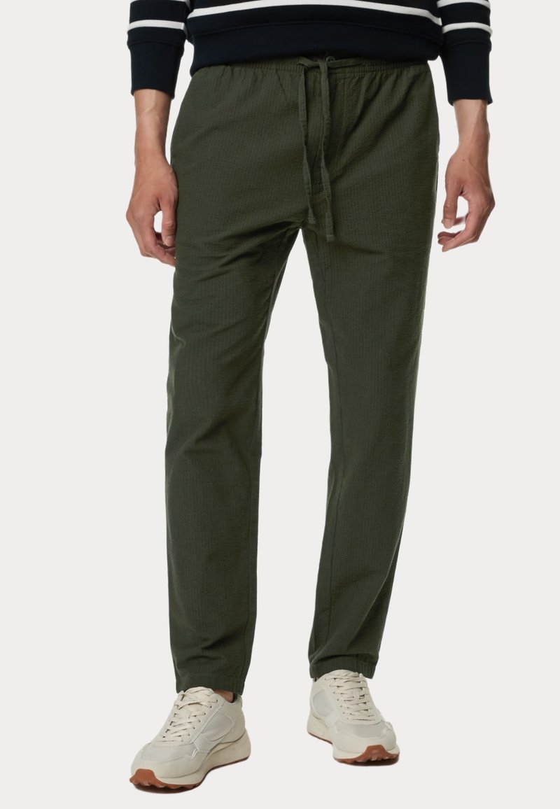 Pantaloni jogger leggeri e verdi con vita elasticizzata e cordino. Presentano tasche laterali e una texture liscia. Adatti per un abbigliamento casual.