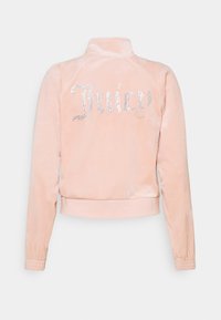 Rosa velourjacka med hög krage, resår vid ärmsluten och rhinestone "Juicy"-logotyp på ryggen. Mjuk textur, kort design.