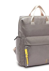 Szary plecak tekstylny z beżowymi paskami, wyposażony w przednią kieszeń na zamek, żółte akcenty i solidną konstrukcję. Gładka tekstura z delikatnymi wzorami.
