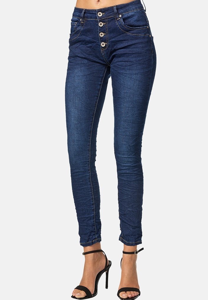 Jeans ajustados de color azul marino con cierre de cinco botones, dos bolsillos frontales y costuras en contraste. Textura de denim suave, diseño de ajuste ceñido.