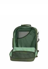 Vihreä reppu, jossa on kaksi osastoa: pääosassa on pehmeä vuori, verkko-tasku ja pehmustettu lokero laitteille. Vetoketjulla suljettava.