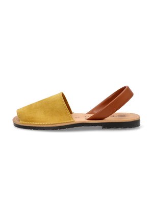 Sandalias de ante amarillas con una correa de cuero marrón, diseño de punta abierta, suela plana de goma negra y costuras visibles a lo largo de los bordes.