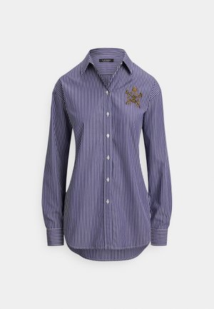 Granatowo-biała koszula w pionowe paski, z długim rękawem, zapięciem na guziki oraz złotym haftowanym herbem na lewej piersi.