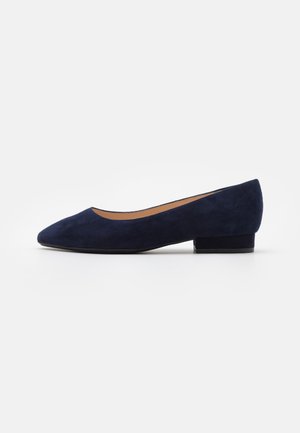 Chaussure femme en daim bleu marine à talon bas avec un bout pointu et un petit talon bloc sur fond blanc.