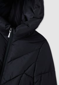 Czarna kurtka puchowa z wysokim kołnierzem, z zamkiem błyskawicznym z przodu i skośnym pikowanym wzorem na tkaninie. Gładka tekstura i matowe wykończenie.