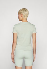 Lys grønn, kortermet t-skjorte med rund hals, laget av mykt materiale. Den har en tettsittende design og en jevn tekstur.
