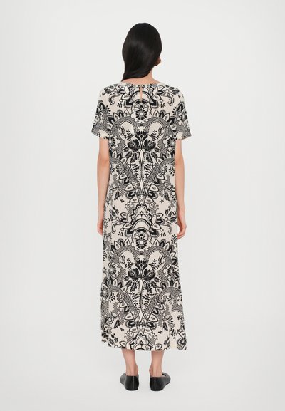 Abito maxi beige con un motivo floreale nero, maniche corte e dettagli a occhiello sul retro. Tessuto morbido con una vestibilità comoda.