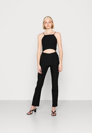 Conjunto black de duas peças com um top justo com alças finas tipo espaguete e um detalhe recortado, combinado com calças flare ajustadas.