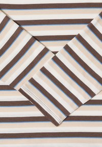 Tissu en coton à manches longues avec des rayures horizontales beige, marron, blanches et de fines lignes bleues, montrant le détail d'une manche pliée.