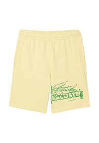 Bermudas de algodón amarillas con un logo de cocodrilo verde y el texto "LACOSTE" en el lado izquierdo. Presenta una cintura elástica y bolsillos laterales.