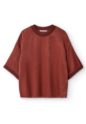 Chemise à manches courtes de couleur rouille profonde, fabriquée à partir d'un tissu lisse. Dotée d'un col ras du cou côtelé et d'une coupe décontractée avec épaules tombantes.