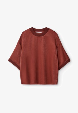 Kortærmet skjorte i dyb rustfarve, lavet af glat stof. Har en ribbet rund hals og en afslappet pasform med sænkede skuldre.