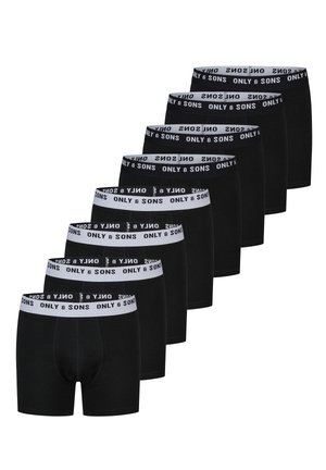 Acht paar zwarte herenslipjes met witte taillebanden met daarop "ONLY & SONS" branding in zwarte tekst.