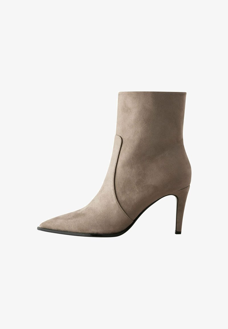 Beige Wildleder-Stiefelette mit spitzem Fuß und schlankem Absatz. Sie zeichnet sich durch ein elegantes Design und eine glatte Textur mit einem asymmetrischen Seitendetail aus.