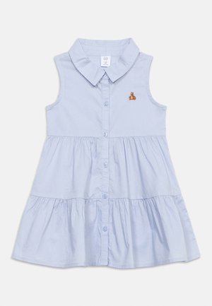 Vestito a strati azzurro chiaro senza maniche, con abbottonatura frontale, colletto appuntito e piccolo orsetto ricamato sul petto sinistro.