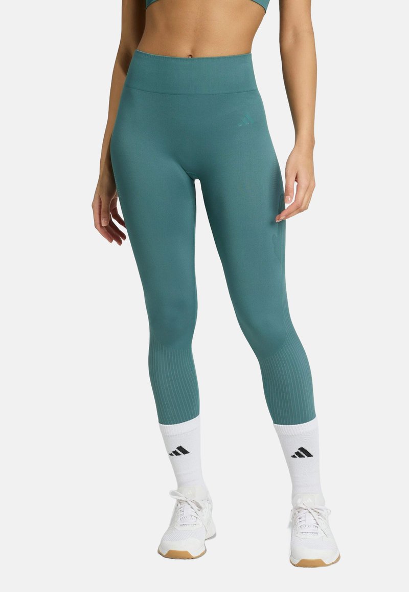 Teal leggings gemaakt van rekbare stof, met een hoge tailleband, geribde enkelmanchetten en subtiele branding bij de taille.