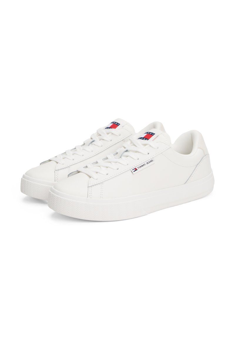 Sneakers bianche realizzate in materiale sintetico liscio, con suola in gomma con texture, design con lacci e logo Tommy Jeans sul lato e sulla linguetta.